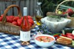 Fresh gazpacho served with rosé wine on a rustic table, surrounded by seasonal ingredients like tomatoes, garlic, and vegetables from Mendoza. Rosado de Familia Furlotti maridaje gazpacho Mendoza