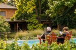 Dos personas de espaldas junto a la pileta de Finca Adalgisa, con el viñedo en primer plano